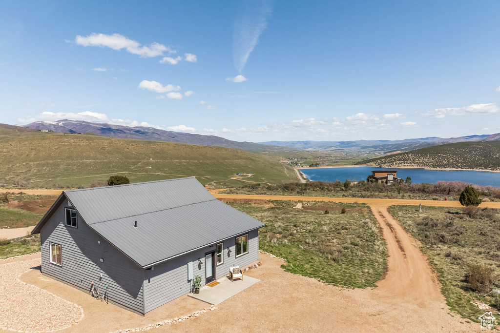 View from above of property with a water and mountain view