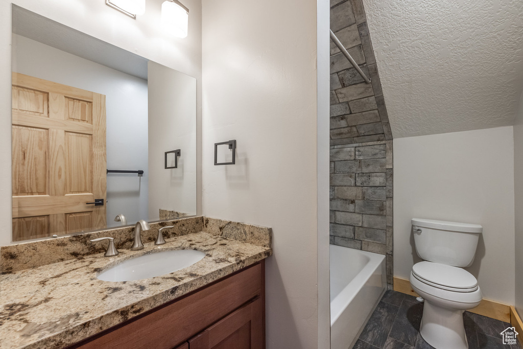 Full bath featuring toilet, vanity, a textured ceiling, and baseboards