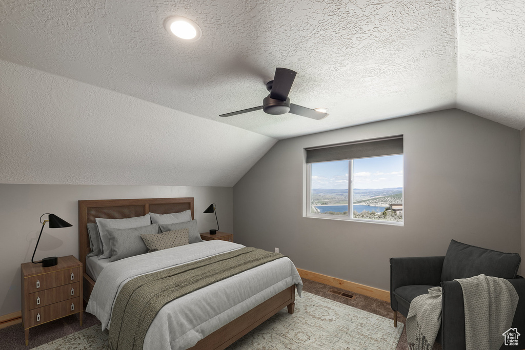 Carpeted bedroom with lofted ceiling, a textured ceiling, baseboards, ceiling fan, and a water view