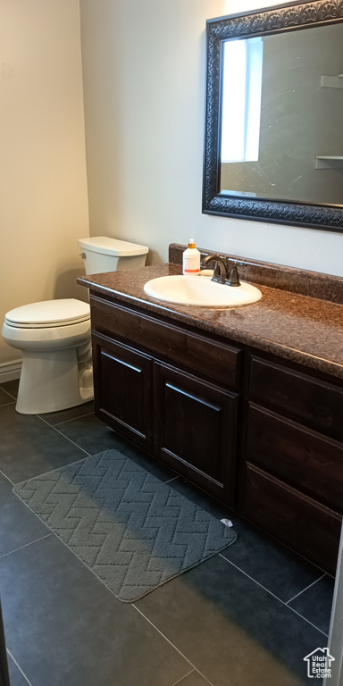 Bathroom with tile patterned flooring, toilet, and vanity