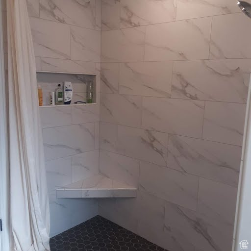 Full bath featuring a tile shower