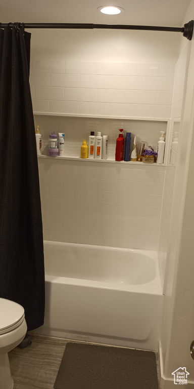 Full bath featuring toilet and shower / tub combo with curtain