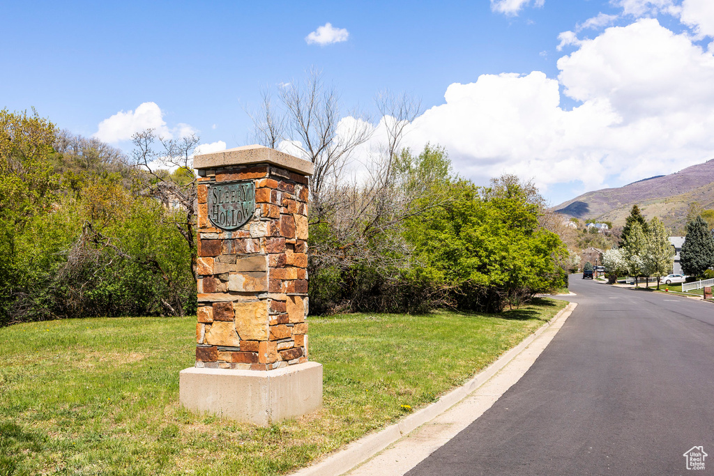 View of asphalt road featuring curbs and a mountain view
