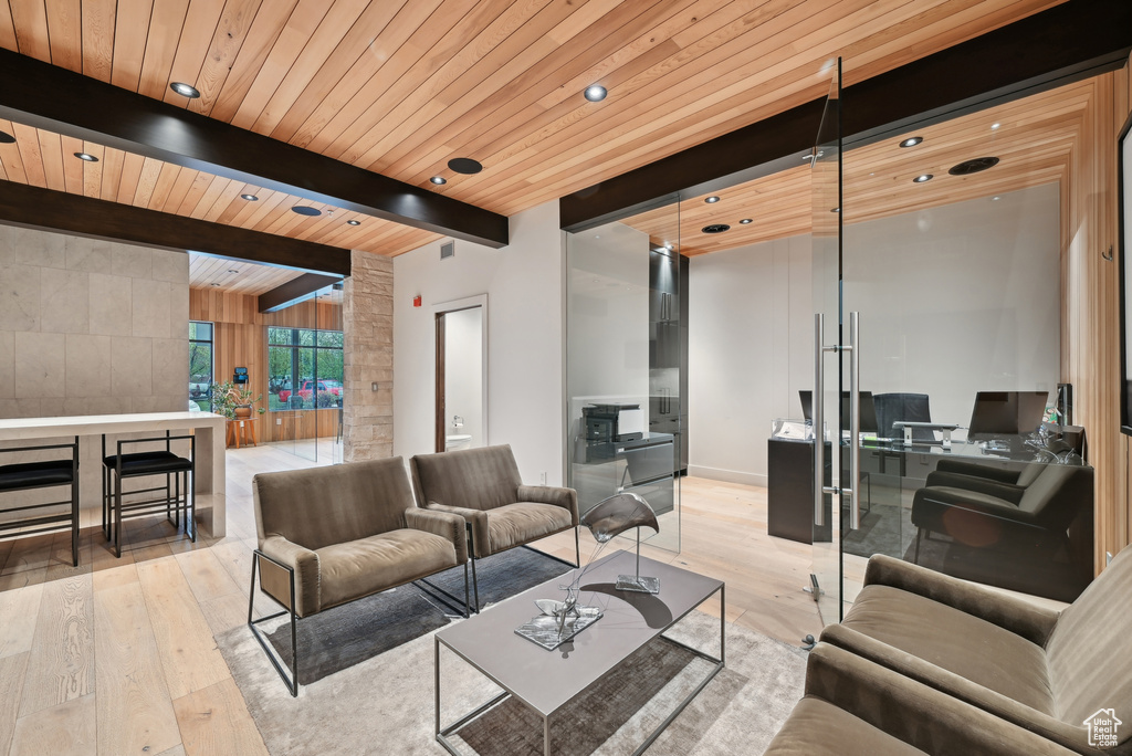 Living room with light wood-type flooring, an office area, beamed ceiling, wooden ceiling, and recessed lighting
