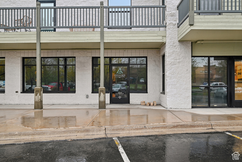 Property entrance featuring a balcony and uncovered parking