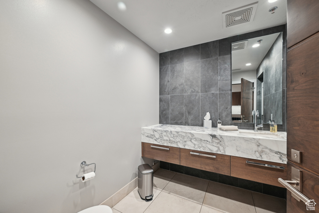 Bathroom featuring tile patterned flooring, vanity, recessed lighting, baseboards, and tile walls