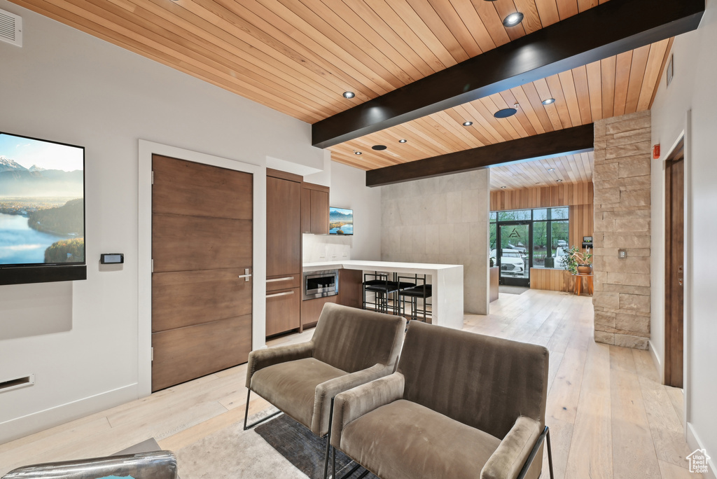 Living area featuring wooden ceiling, light wood-style flooring, and beamed ceiling