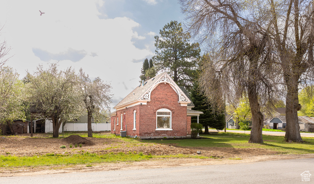View of property exterior featuring brick siding and fence