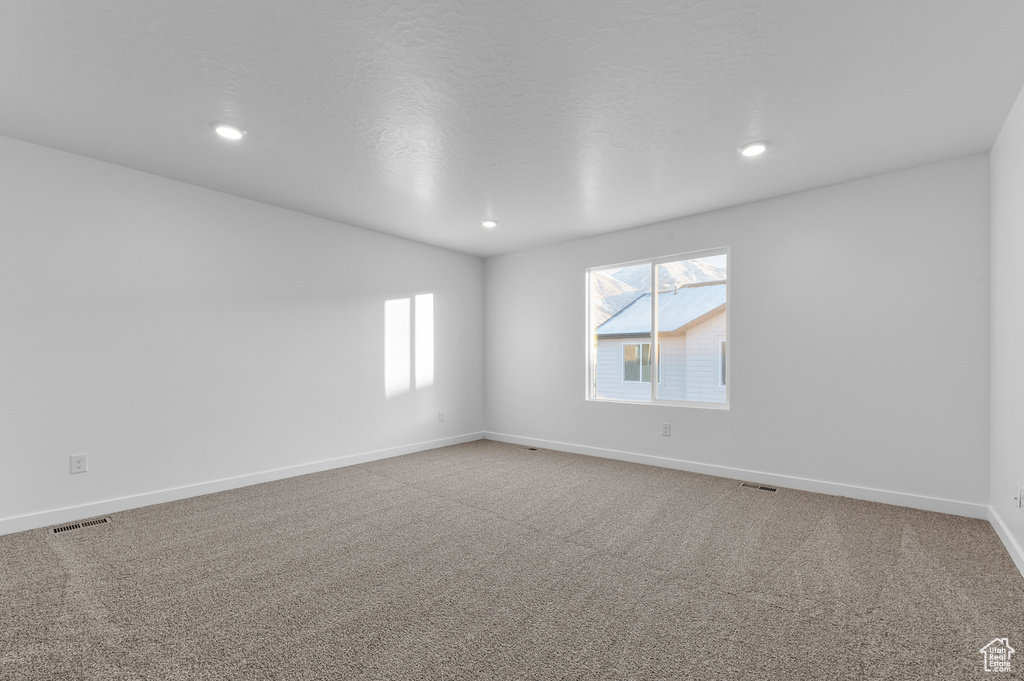 Empty room featuring baseboards, recessed lighting, and carpet flooring
