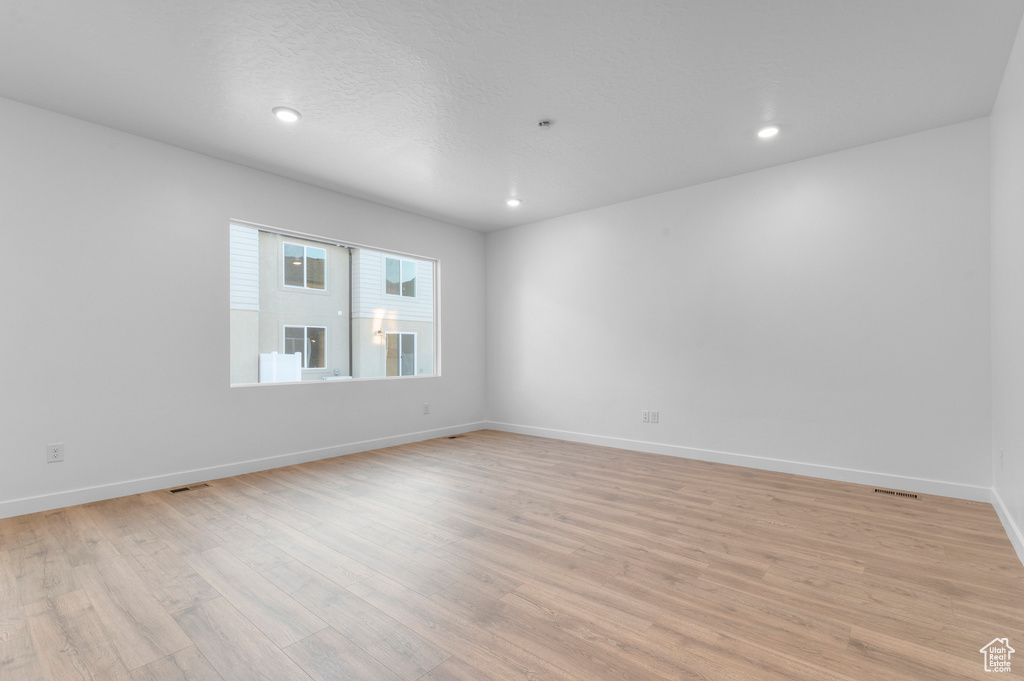 Unfurnished room featuring light wood-type flooring, recessed lighting, and baseboards