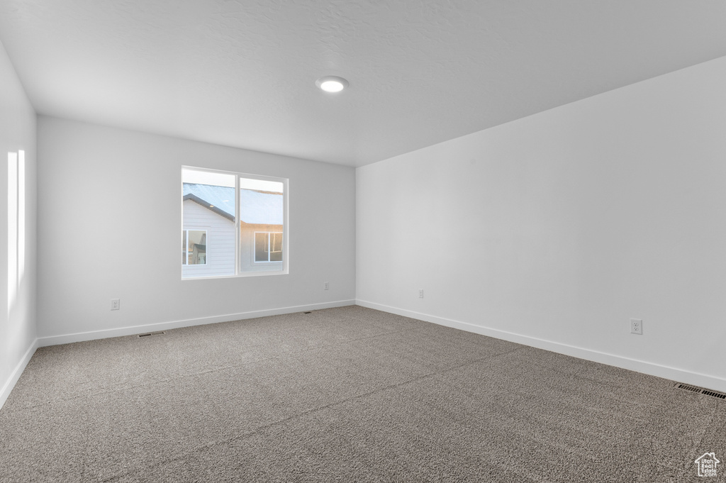 Unfurnished room featuring baseboards and carpet flooring