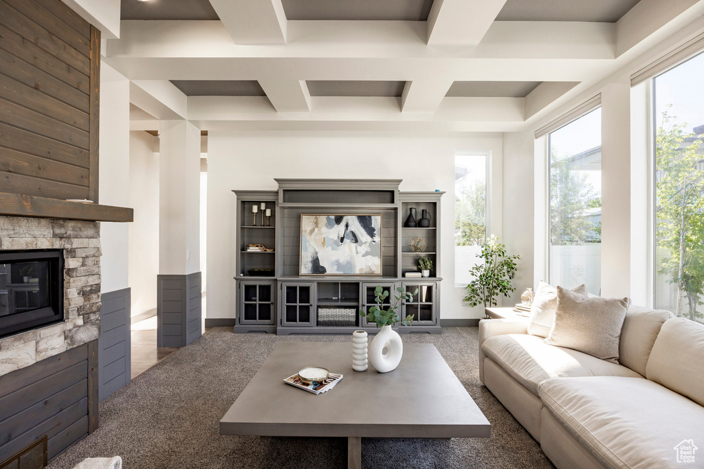 Living area with a fireplace, coffered ceiling, and beamed ceiling
