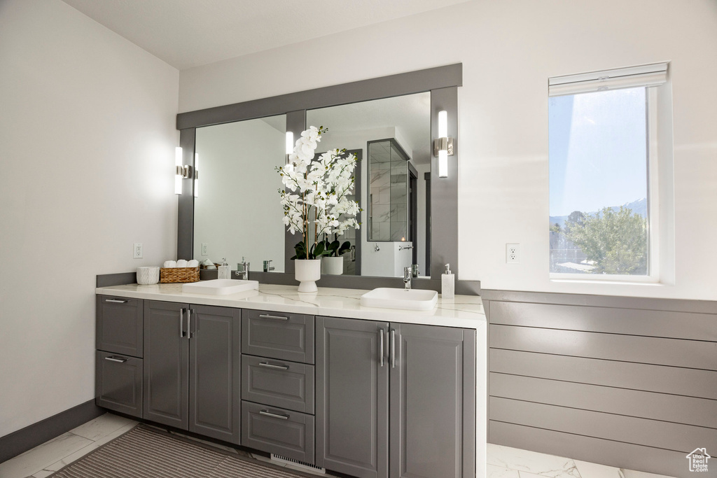 Full bathroom with marble look tile flooring and double vanity