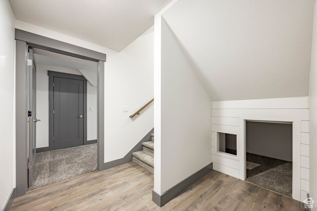 Additional living space with light wood finished floors, stairs, and baseboards