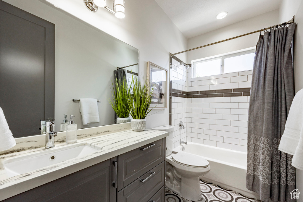 Bathroom featuring shower / bath combo, vanity, and toilet