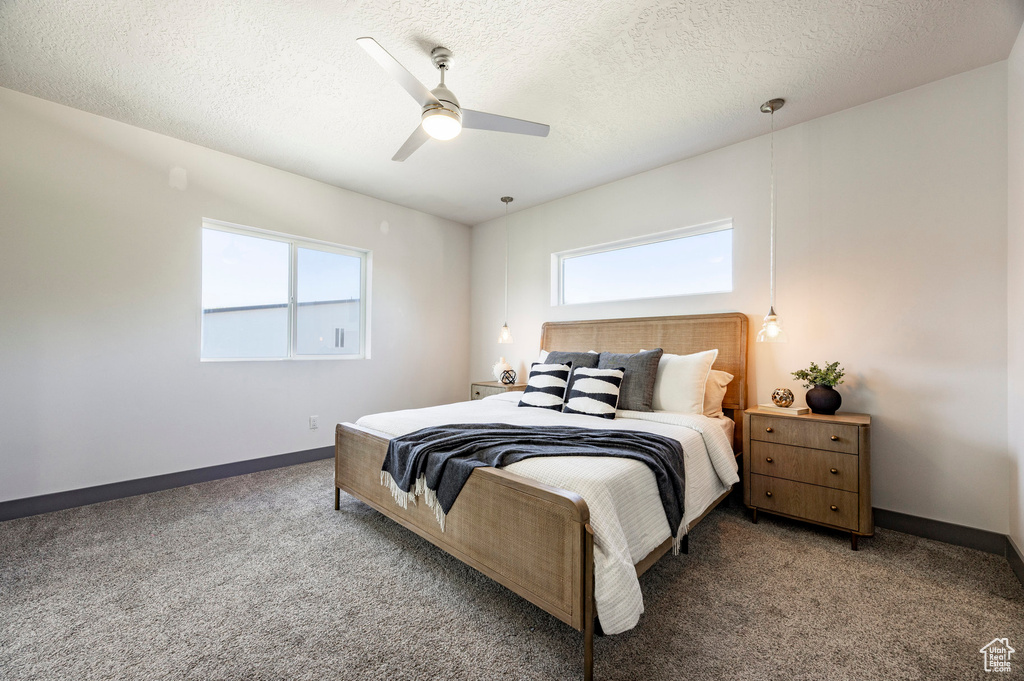 Carpeted bedroom with baseboards, a ceiling fan, and a textured ceiling