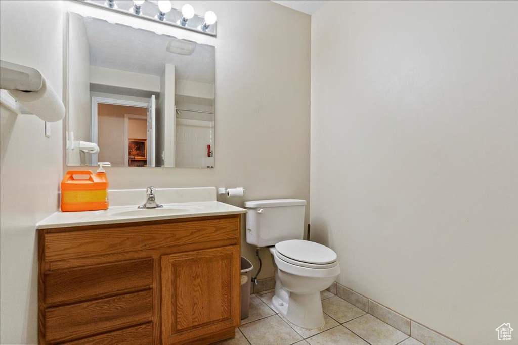 Bathroom with tile patterned flooring, toilet, vanity, and baseboards