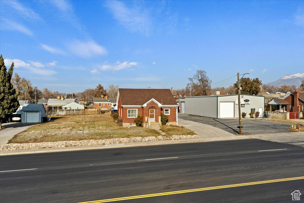 View of front of property with a detached garage, a residential view, and a mountain view