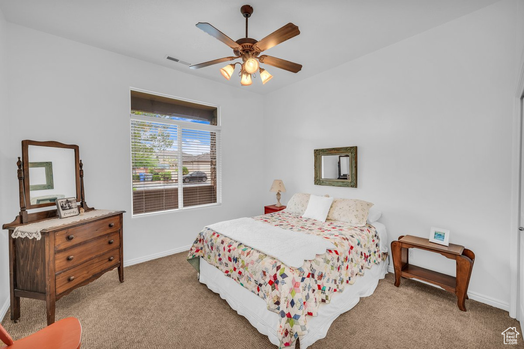 Carpeted bedroom with baseboards and a ceiling fan