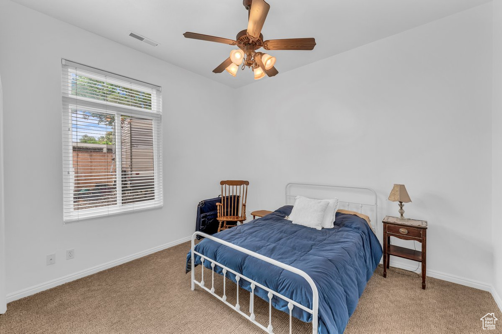 Carpeted bedroom with baseboards and ceiling fan