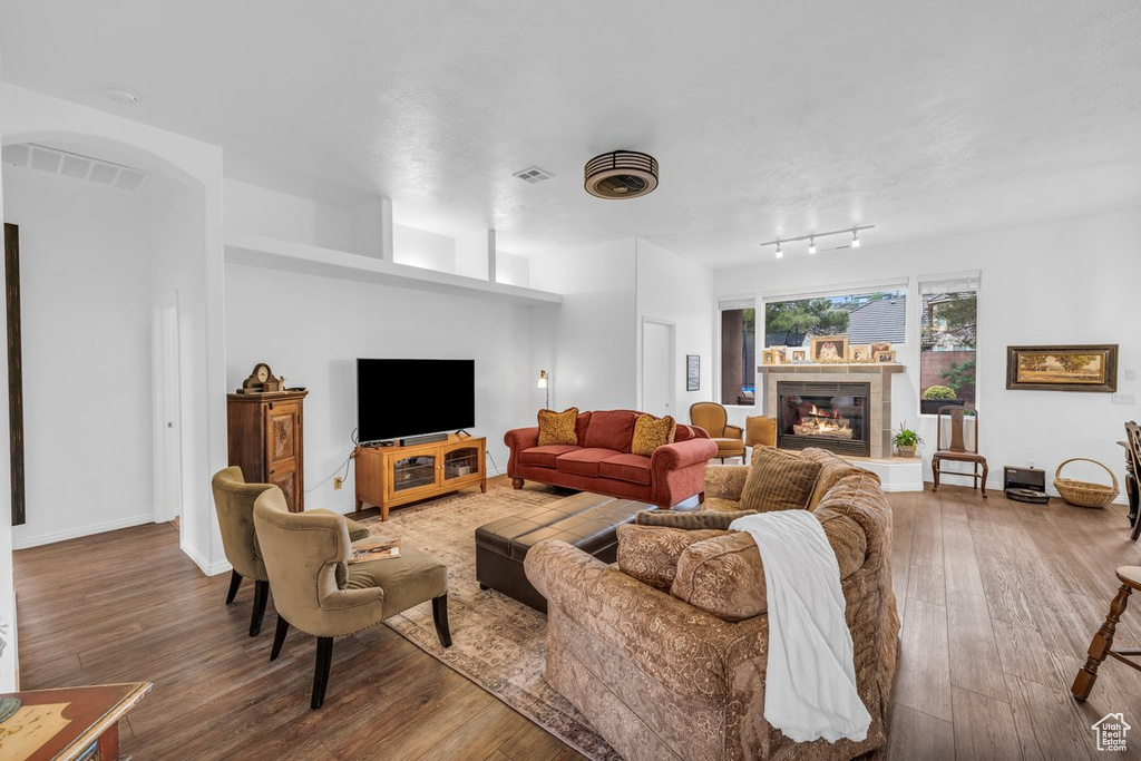 Living area featuring hardwood / wood-style floors, a tiled fireplace, and baseboards