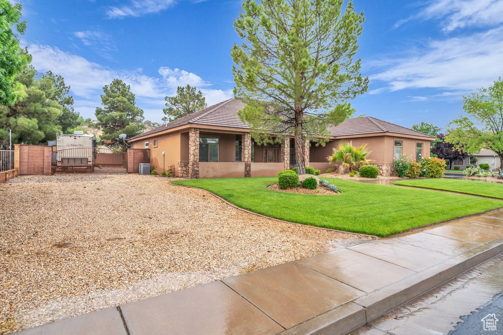 View of front of property featuring a gate, stucco siding, driveway, a tiled roof, and stone siding