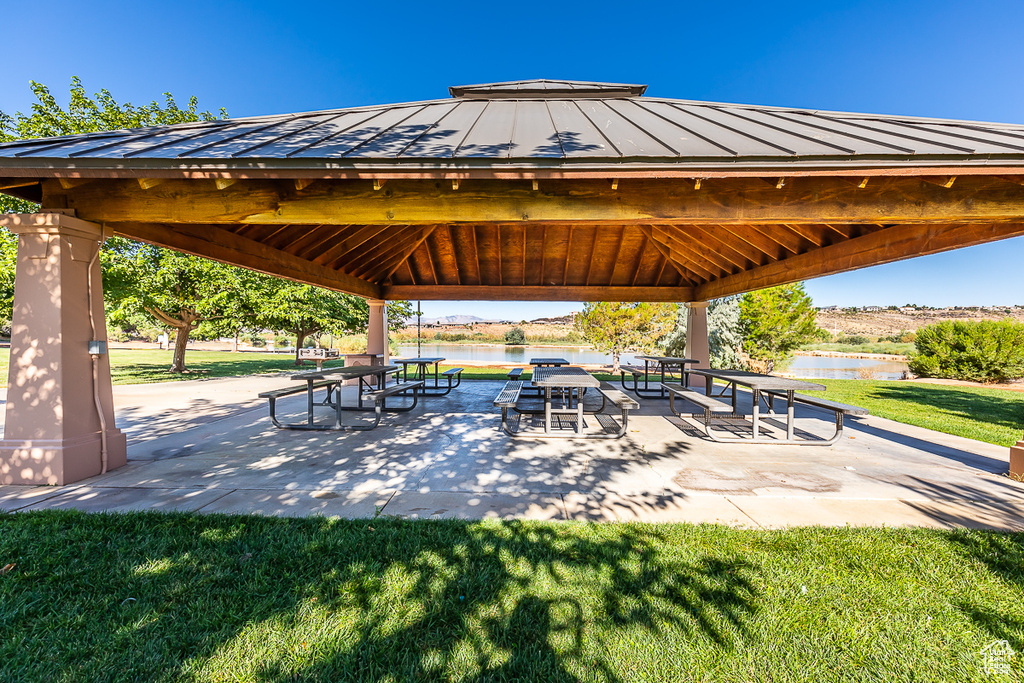 View of property's community with a gazebo, a water view, and a yard