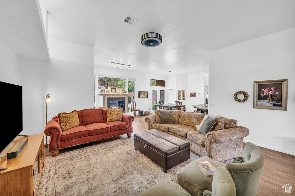 Living room with wood finished floors, baseboards, and a tiled fireplace