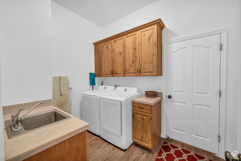 Laundry area featuring cabinet space, separate washer and dryer, and light wood-type flooring