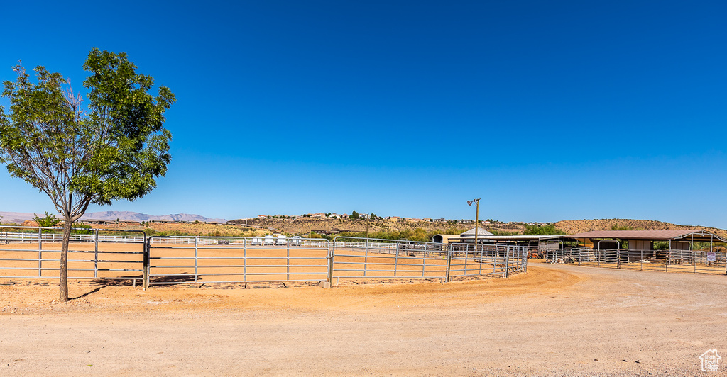 View of yard featuring an outdoor riding arena, a view of countryside, a mountain view, and fence