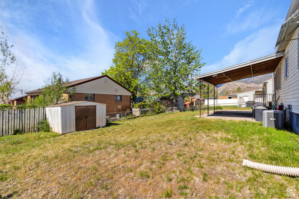 View of yard featuring a storage shed, central AC unit, and an outdoor structure