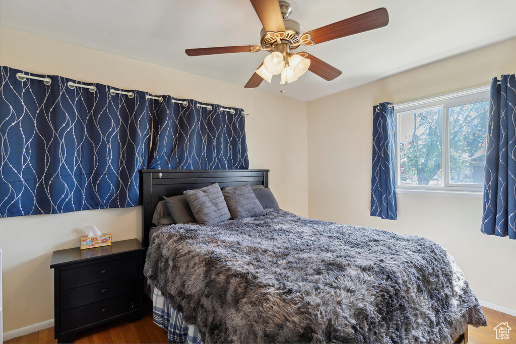 Bedroom featuring wood finished floors, baseboards, and a ceiling fan