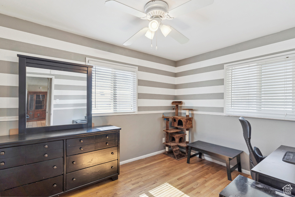 Office with a ceiling fan, light wood-type flooring, and baseboards