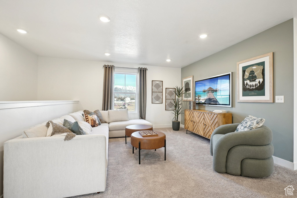 Living area with light carpet, recessed lighting, and baseboards