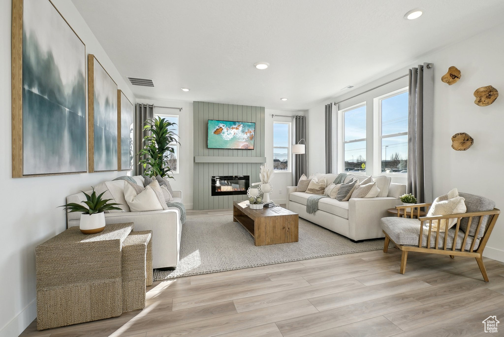 Living area featuring light wood finished floors, a large fireplace, and recessed lighting