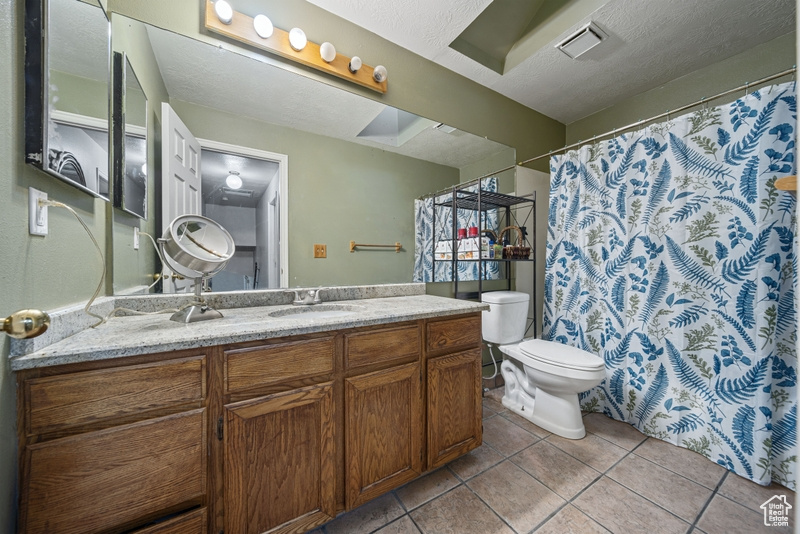 Full bath with tile patterned floors, toilet, and vanity