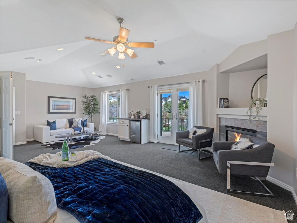 Carpeted bedroom featuring lofted ceiling, a fireplace, baseboards, access to exterior, and recessed lighting