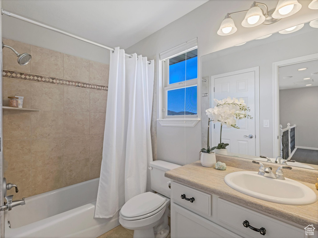 Full bathroom with shower / tub combo with curtain, toilet, and vanity