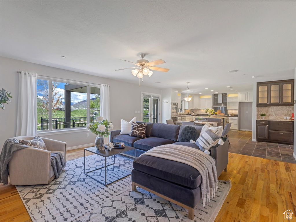 Living area with plenty of natural light, a ceiling fan, light wood-style flooring, and recessed lighting