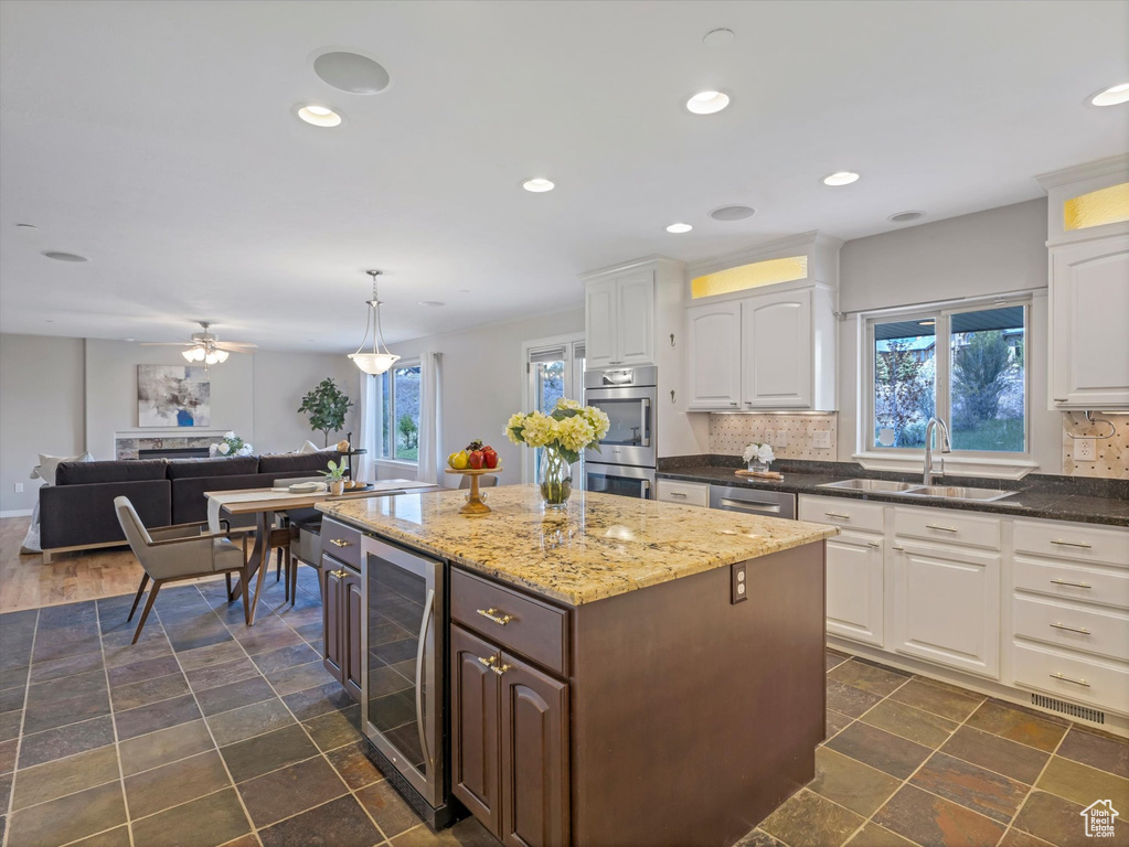 Kitchen featuring a sink, beverage cooler, appliances with stainless steel finishes, healthy amount of natural light, and recessed lighting