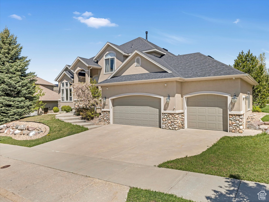 View of front of house with stucco siding, an attached garage, concrete driveway, a shingled roof, and stone siding