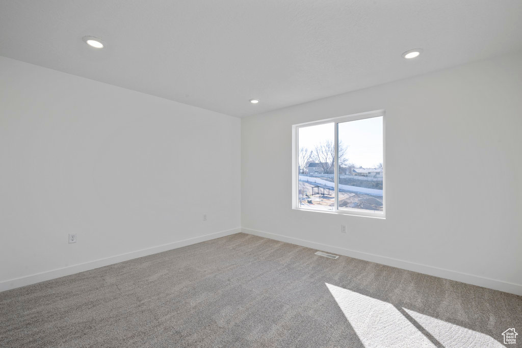 Spare room featuring carpet flooring, recessed lighting, and baseboards