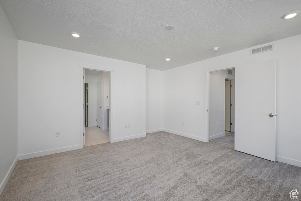 Unfurnished room with light carpet, recessed lighting, a textured ceiling, and baseboards