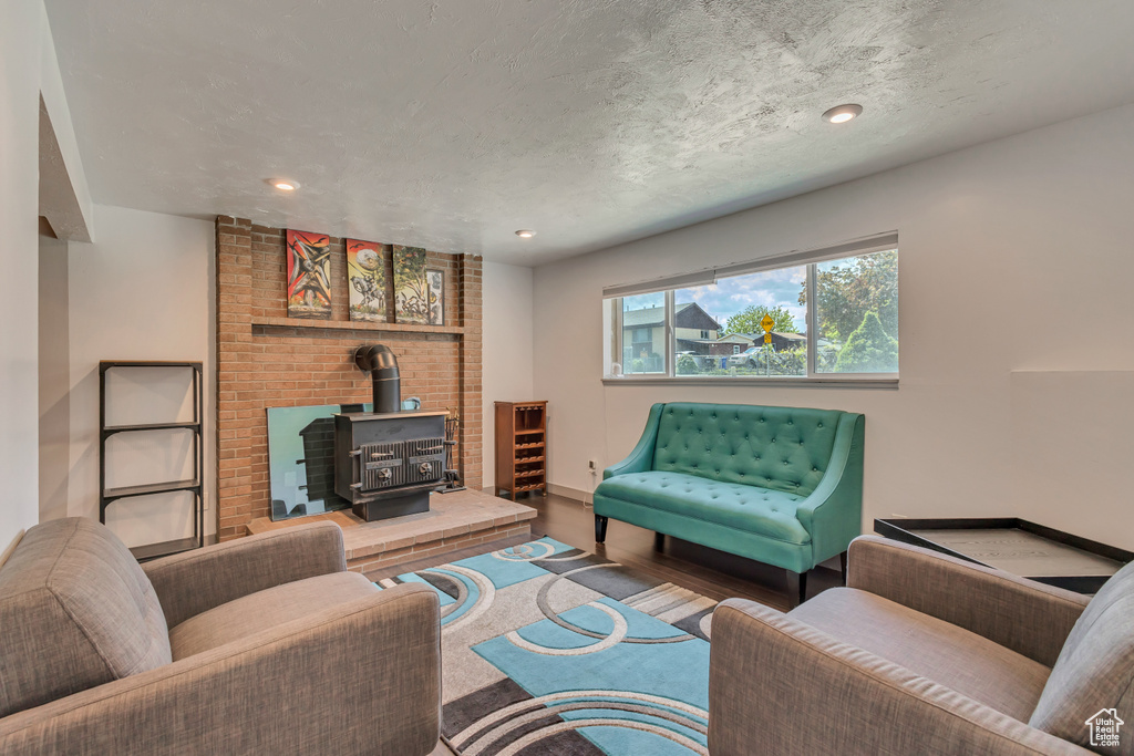 Living area featuring a wood stove, recessed lighting, wood finished floors, and baseboards