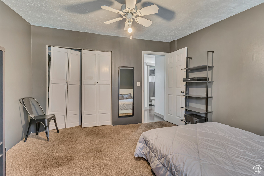 Bedroom with carpet flooring, a closet, a textured ceiling, and ceiling fan