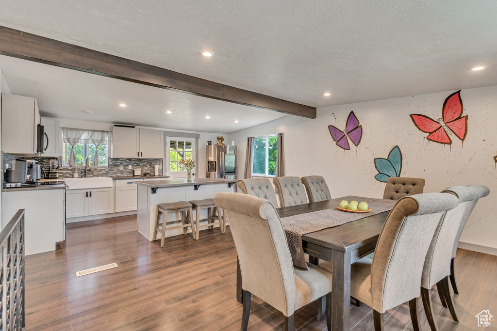 Dining space with recessed lighting, beam ceiling, and wood finished floors