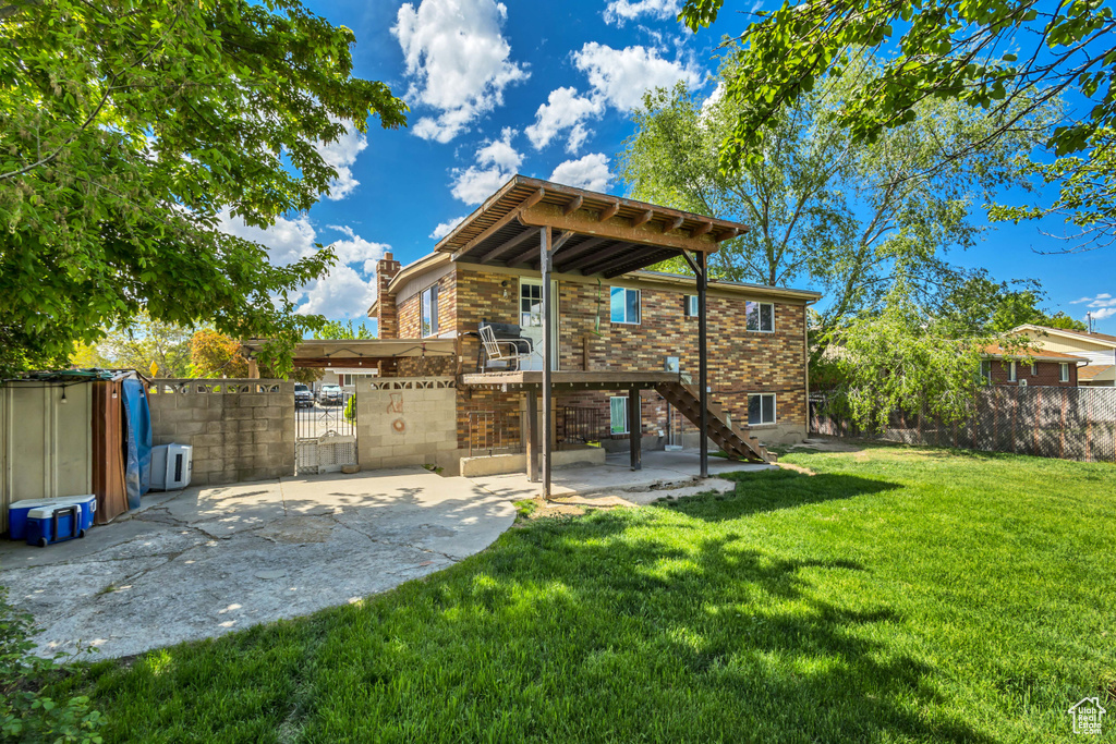 Rear view of property featuring a gate, brick siding, a chimney, and stairs