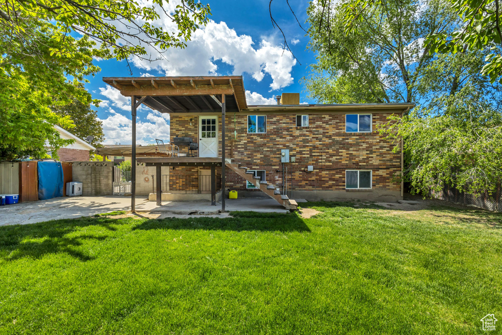 Back of property featuring stairway, a patio area, and brick siding