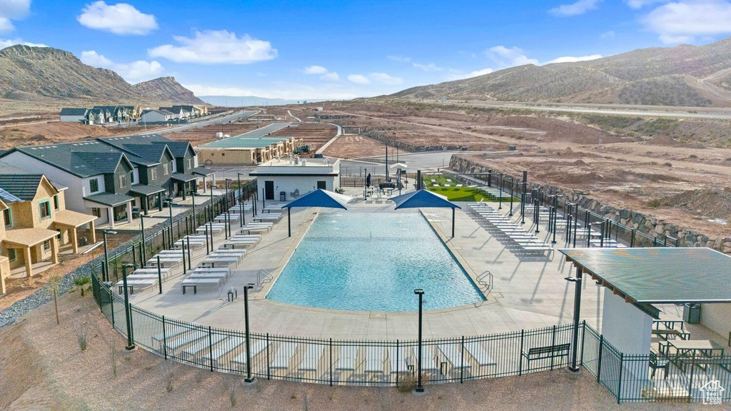 Community pool with fence and a mountain view