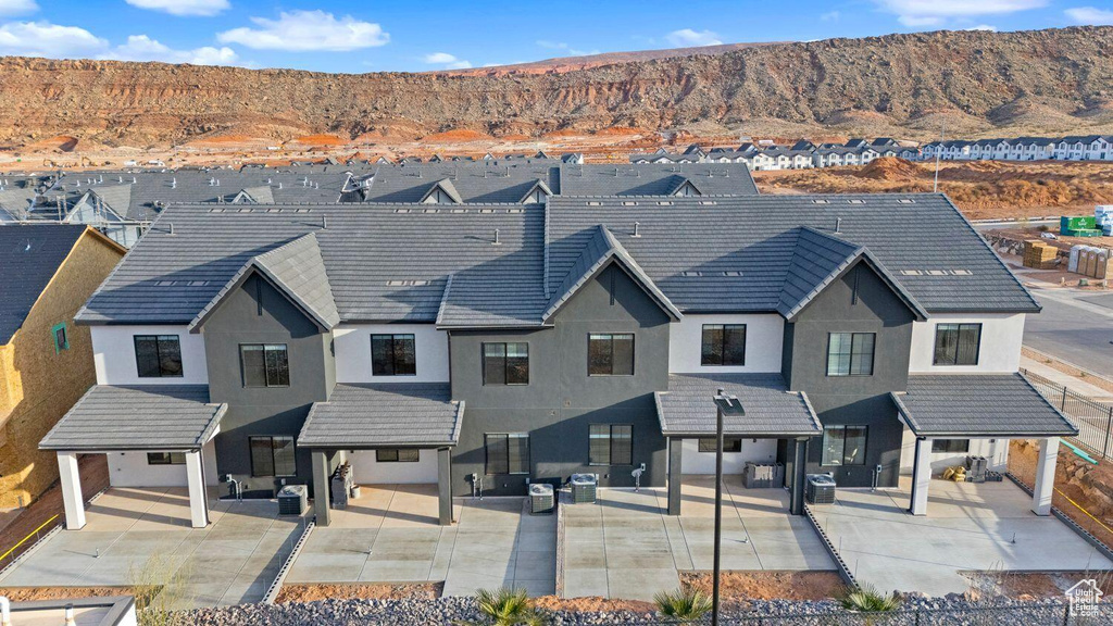 View of front facade with stucco siding, a mountain view, and an outdoor living space